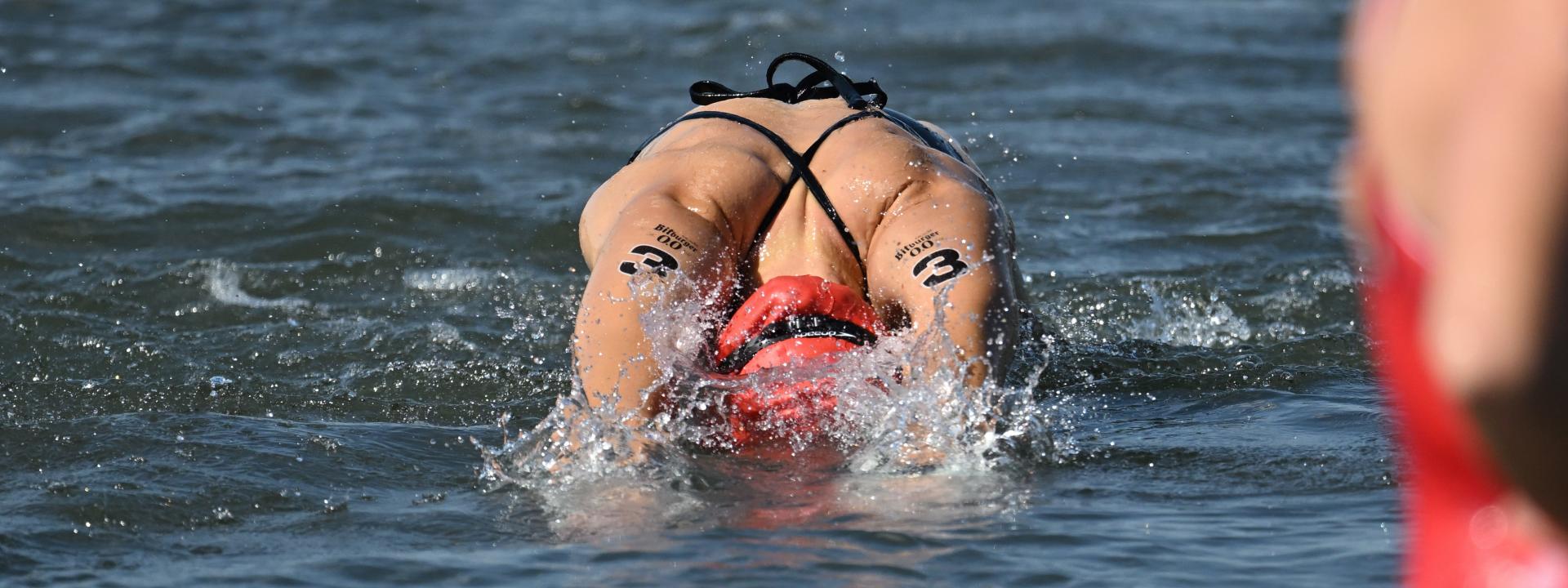 Athletin springt im Wasser. 