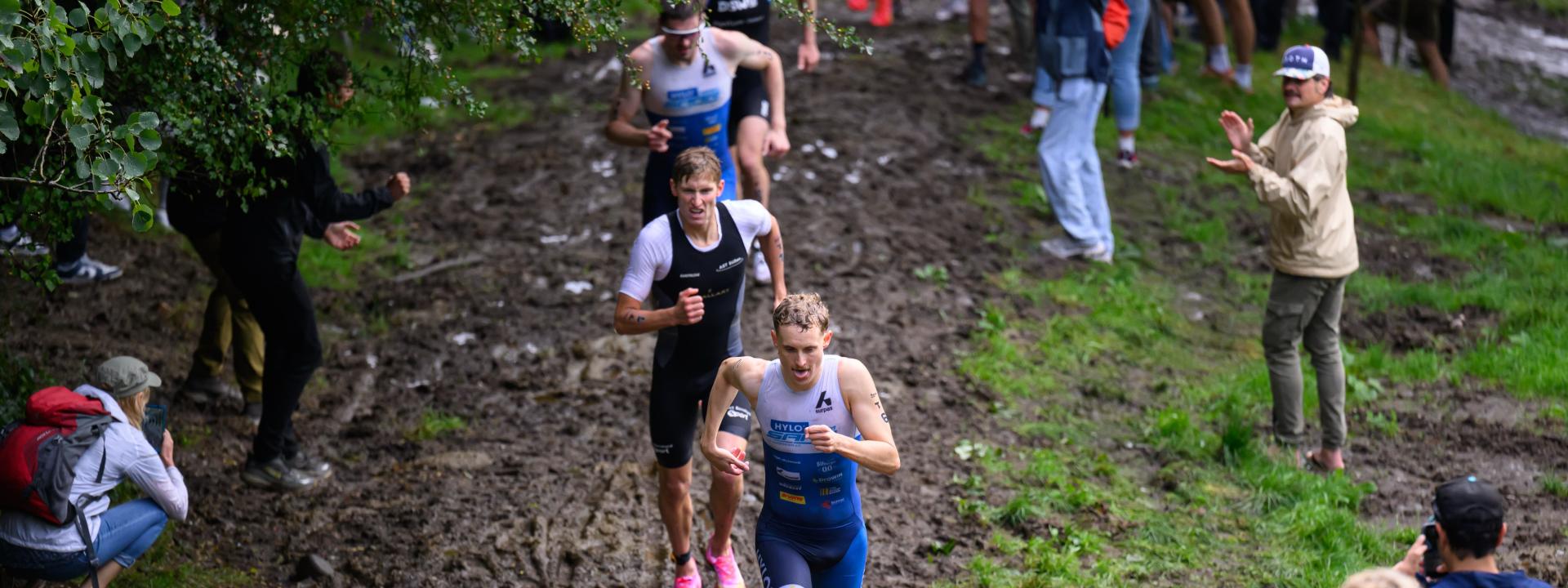 Mehrere Männer laufen im Rahmen eines Triathlons den Kuhsteig, einen legendär steilen Anstieg hoch