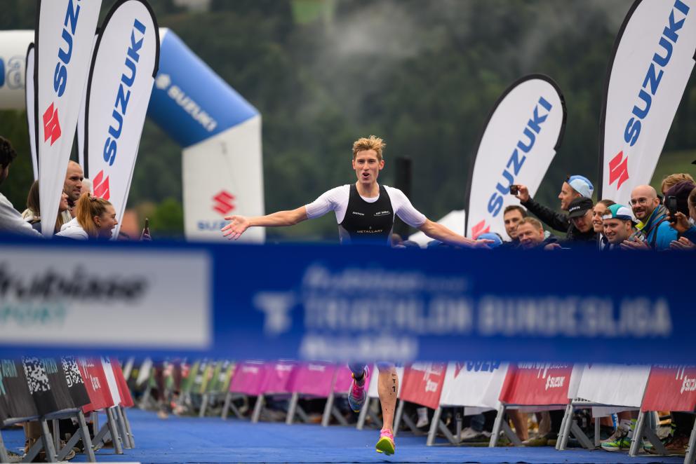 Ein Triathlet feiert seinen Sieg auf den letzten Metern ins Ziel