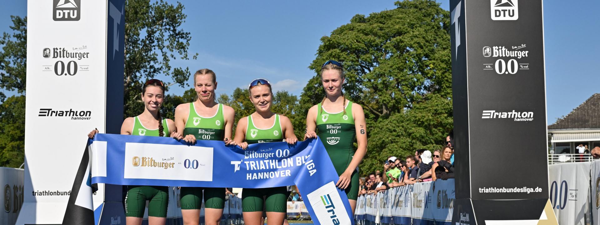 Triathlon Potsdam posiert vor dem Zielbogen