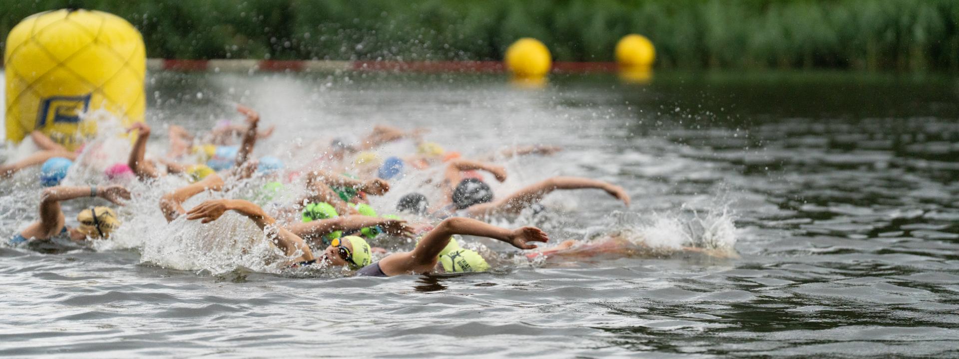 Gruppe schwimmt an Boje vorbei