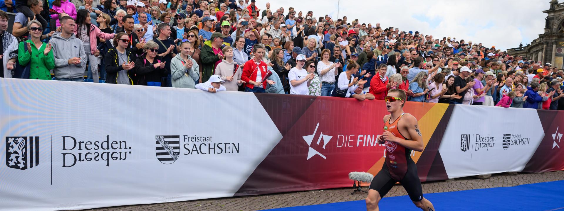 Mann läuft an Zuschauern und Die Finals Banner vorbei