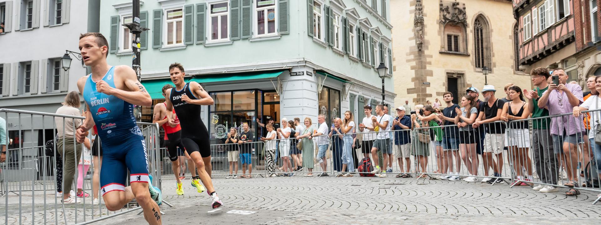 Männer laufen über Kopfsteinpflaster in der Tübingen Altstadt