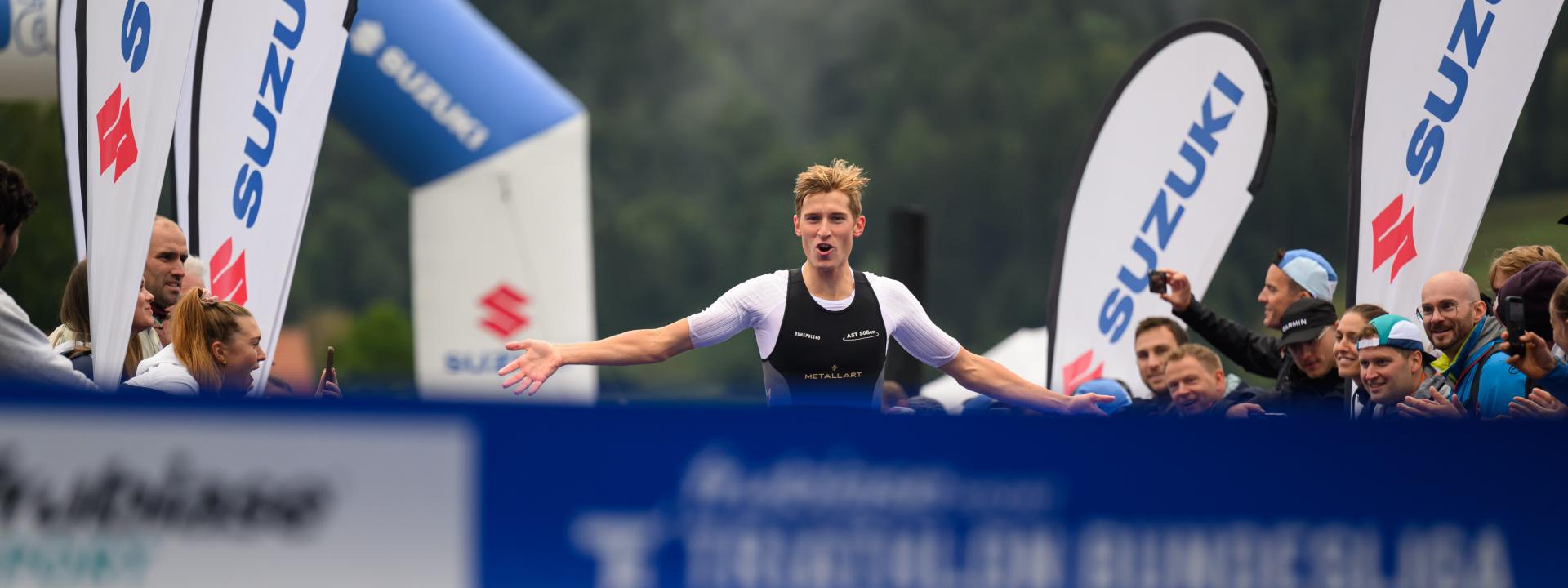 Ein Triathlet feiert seinen Sieg auf den letzten Metern ins Ziel