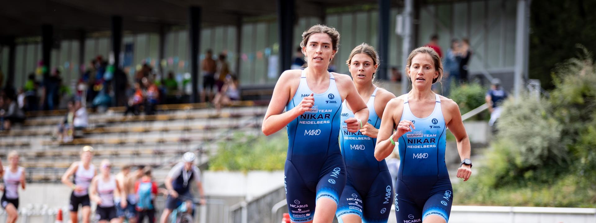 drei Frauen laufen im Team über die Tartanbahn