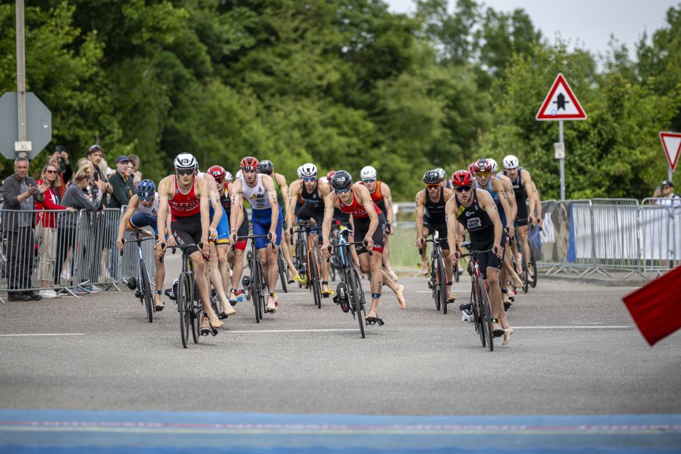 Gruppe von Triathleten fahren in die Wechselzone, bereit zum Absteigen