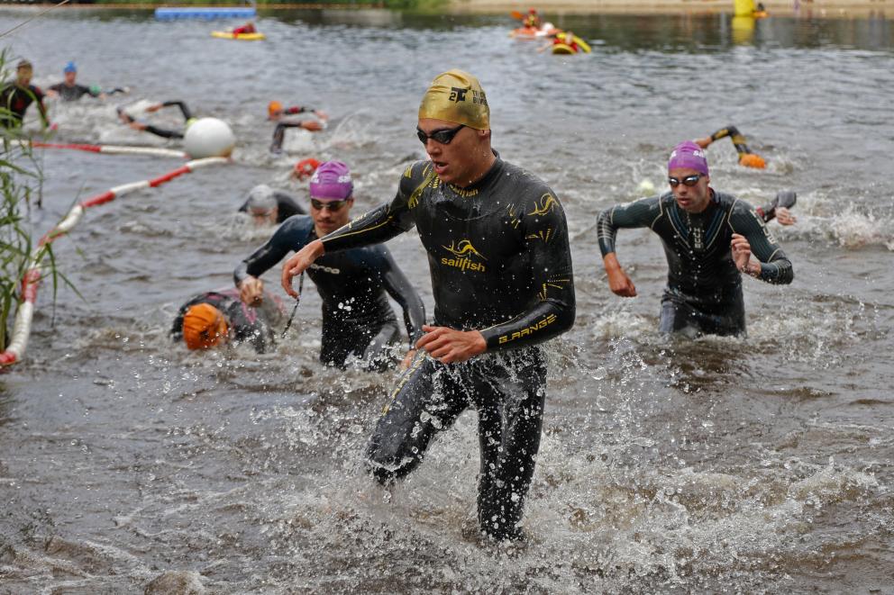 Männer steigen nach dem Schwimmen aus dem Wasser