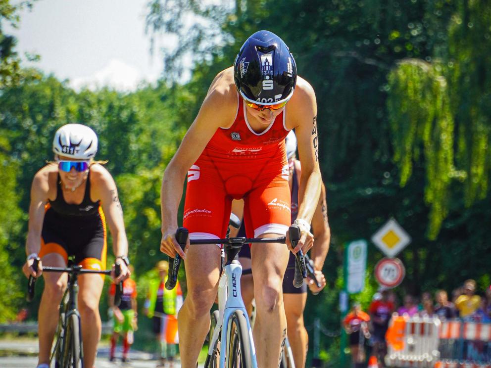 Frau auf Rad tritt in die Pedalen und fährt das Team zum Sieg