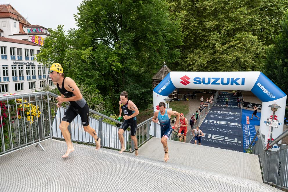 Bundesliga-Männer laufen die Treppe vom Schwimmaustieg zur Wechselzone hoch