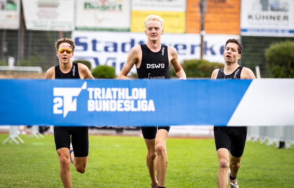 Männer aus Darmstadt laufen auf das Zielbanner zu