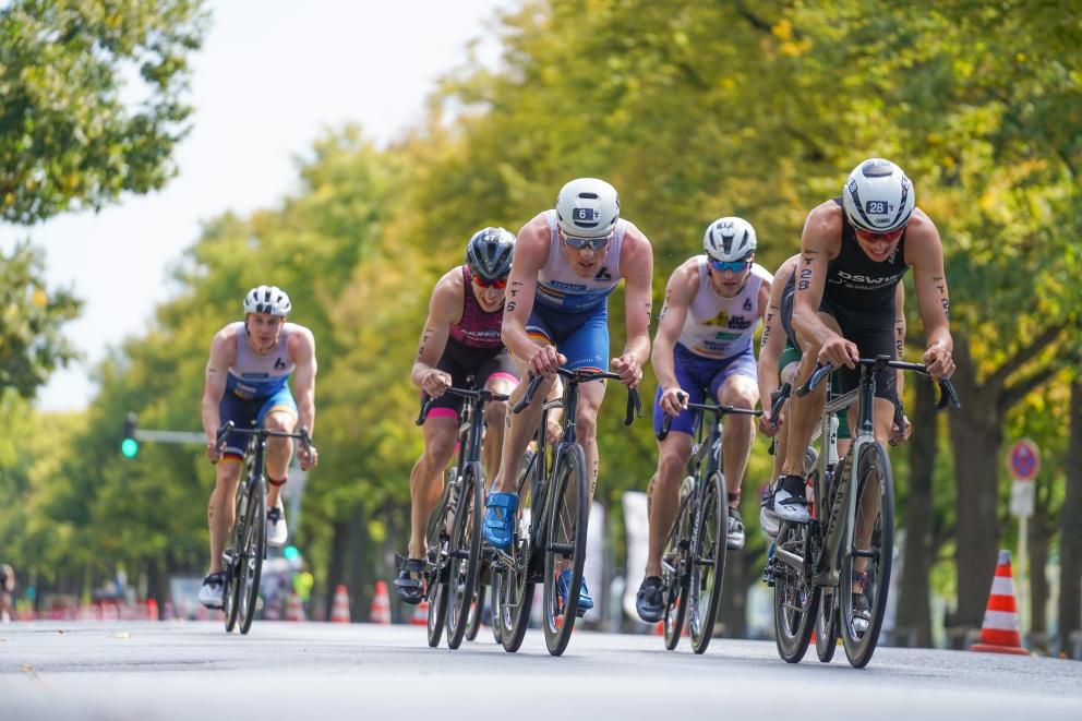 Mehrere Sportler fahren in einem Triathlonrennen Rad
