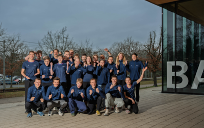 Mehrere Sportlerinnen und Sportler posieren im gleichen Auftritt für ein Teamfoto