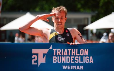 Athlet der 2. Liga läuft auf Zielbanner hoch macht Militärgruß