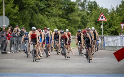 Gruppe von Triathleten fahren in die Wechselzone, bereit zum Absteigen
